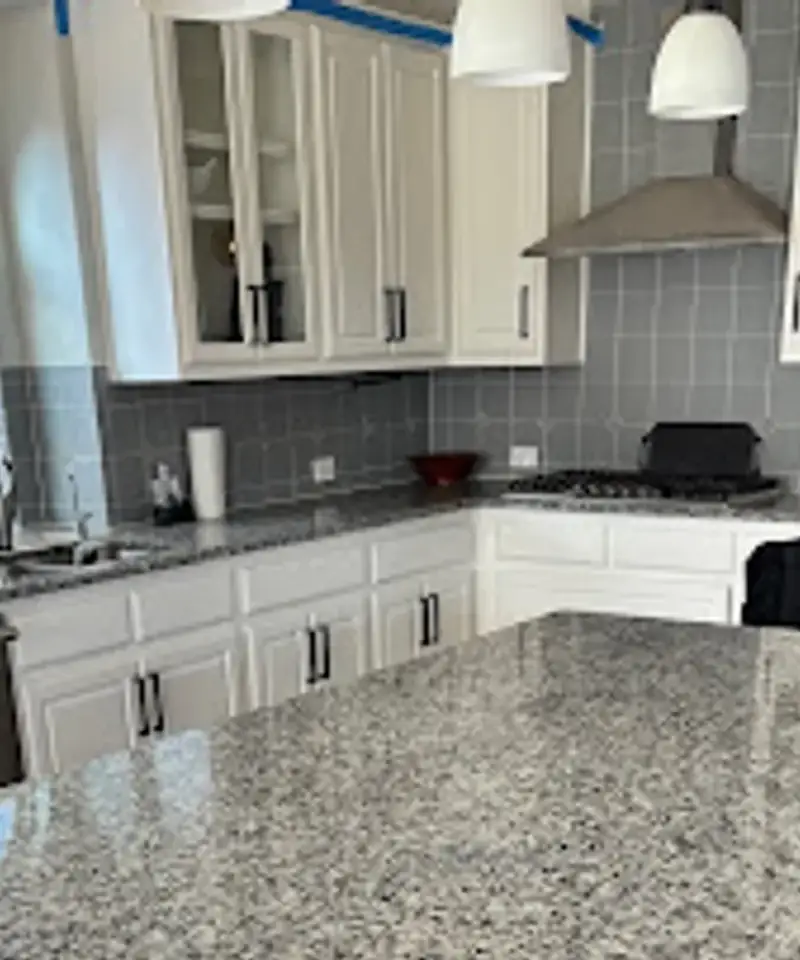 Clean kitchen with white cabinets and granite counters